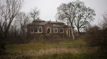 Крихітна лялька між рамами вікон