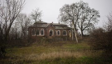Крихітна лялька між рамами вікон