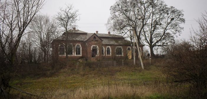 Крихітна лялька між рамами вікон